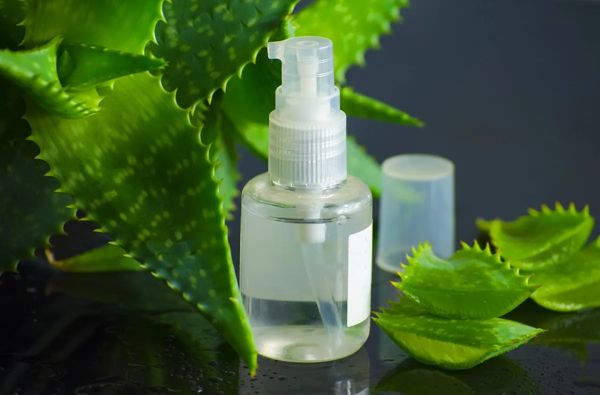 Flacon spray aloe vera sur table humide.