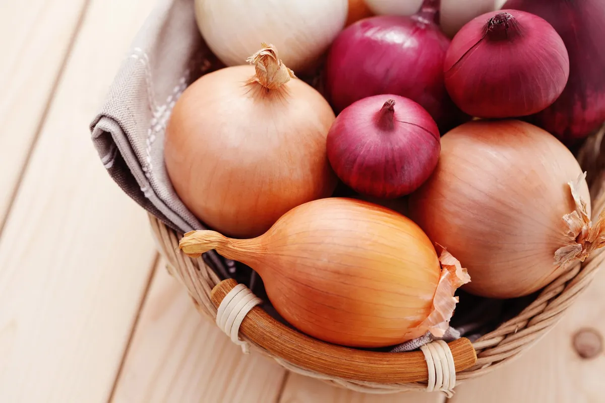 Oignons variés dans un panier en osier.